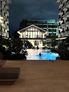 a person in a pool in a building at night at Lay Cozy Mactan- Condo Staycation and Layovers in Pusok