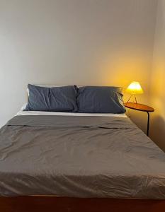 a bed in a bedroom with a lamp on a table at Lay Cozy Mactan- Condo Staycation and Layovers in Pusok +5 photos