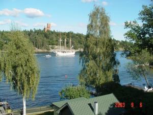 a view of a river with a boat in the water at Serene lakeside cabin next to the sea just 10 minutes from Stockholm city in Solna +7 photos
