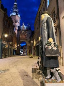 Una estatua de una persona con un bolso en una calle. en Le Philibert Roux, en Auxerre