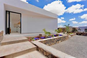 a white house with a stone wall and stairs at Villa Lima by Aura Collection in La Oliva +30 photos