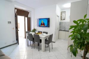 a dining room with a white table and chairs at Casa ITRIA 13 in Agrigento
