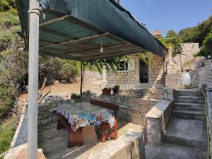 a picnic table under a canopy in a stone house at House Rasohatica Tare in Korčula