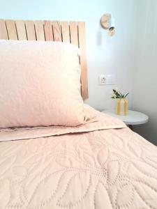 a bed with a pink comforter and a pillow at Julia's Home in Patitiri