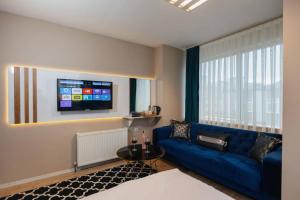 a living room with a blue couch and a tv at Lina Suit Otel in Istanbul