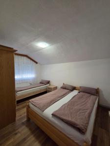 a bedroom with a bed and a bench in it at Biser-Hatinac in Bihać