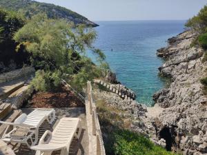 a group of chairs sitting next to the ocean at House Rasohatica Tare in Korčula