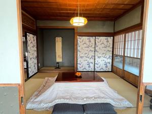 a room with a bed in the corner of a room at 城下町小諸の古民家 - 町屋の隠れ宿-椛庵 Japanese old folk house - momijian in Komoro