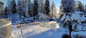 a yard covered in snow with a house and a pool at Brummett Lodge in Bass Lake