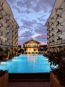 a large swimming pool in the middle of two buildings at Luxury Budget one Bedroom with living room and Kitchen Rest and fly at Amani Grand Resort in Pusok