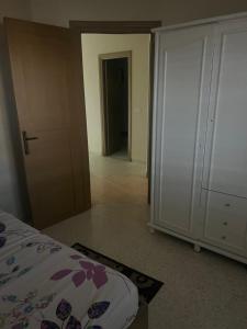 a bedroom with a bed and a closet and a door at Appartement nasria in Sfax +1 photo
