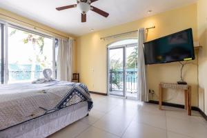 a bedroom with a bed and a flat screen tv at Cheerful 4 Bedroom house with Swimming Pool in Mezcales