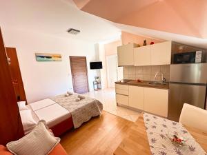 a small kitchen with a bed and a refrigerator at Apartments Vila Miranda in Vodice