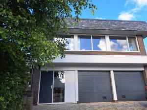 a house with two garage doors at Chang in Egmond aan den Hoef
