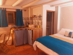 a bedroom with a bed and a small kitchen at Historical Center Apartments in Cusco