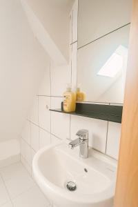 a white bathroom with a sink and a mirror at Small House park free at street in Stuttgart