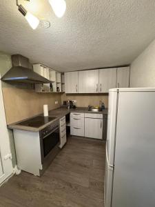 a kitchen with white cabinets and a refrigerator at Small House park free at street in Stuttgart +2 photos