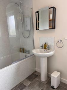 a white bathroom with a sink and a shower at Williamsfield Cottage in Holywood +32 photos