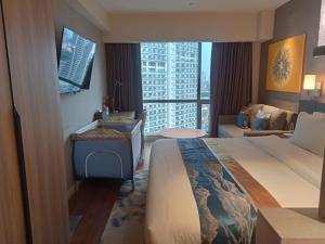 a hotel room with a bed and a large window at Novotel Suites Celestia at Hotel Residences Manila in Manila