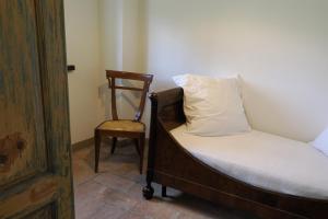 - un lit et une chaise dans une chambre dans l'établissement La Rocca -- Monticello Apartments, à Medesano