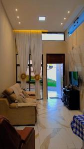 ein Wohnzimmer mit Sofa und Fernseher in der Unterkunft Festa de São João cg in Campina Grande