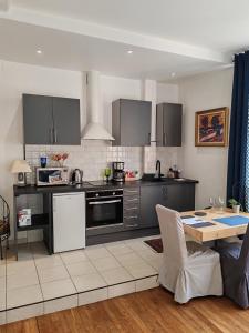 a kitchen with stainless steel appliances and a table at Le Jean Jaurès in Troyes