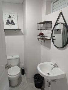 a white bathroom with a toilet and a sink at Cebu Airport budget Luxury living Rest& Fly at Amani Grand Resort in Pusok +3 photos