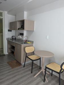 a kitchen with a table and two chairs and a table at Cebu Airport budget Luxury living Rest& Fly at Amani Grand Resort in Pusok