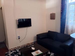 a living room with a couch and a tv on the wall at Vera Cruiz one bedroom CBD in Malindi