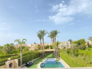 a view of a pool with palm trees at فيلا راقية تاني صف بحيرة in El Alamein