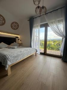 a bedroom with a bed and a large window at Wierchowe Zacisze in Bukowina Tatrzańska