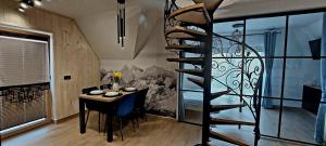 a room with a dining table and a spiral staircase at Wierchowe Zacisze in Bukowina Tatrzańska +27 photos