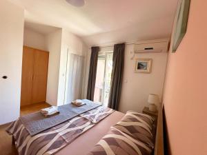 a bedroom with a bed and a window at Apartments Vila Miranda in Vodice