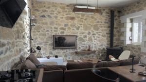 依拉佩特拉Thysanos的带沙发和石墙的客厅