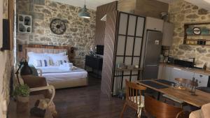 a bedroom with a bed and a table and a kitchen at Thysanos in Ierapetra