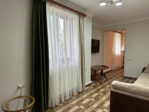 a living room with a couch and a large window at TAGANI Guest Rooms in Martuni