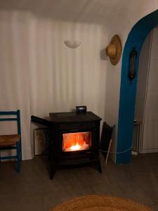 a fireplace in a living room with a blue chair at Blue house Nature and calm in Tarifa
