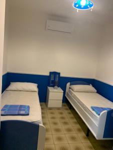 due letti in una stanza con pareti blu e bianche di La casa sul blu Acciaroli Casa Vacanze ad Acciaroli