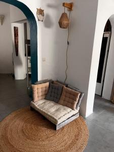 a couch sitting on a rug in a living room at Blue house Nature and calm in Tarifa