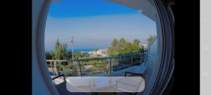 a view from a window of a balcony with a table at Manas Rooms in Dhërmi