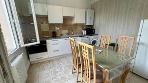 a kitchen with a table and chairs and a kitchen with white cabinets at Oasis de verdure en centre-ville - jacuzzi privé in Mandelieu-la-Napoule +28 photos