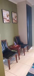 a waiting room with three chairs and a table at Lot 3127, Modipane in Gaborone
