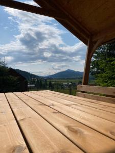 a wooden picnic table with a view of the mountains at Cabana Lapina in Vatra Dornei
