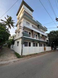 a tall white building on the side of a street at Zion Inn Home Stay in Eraniel