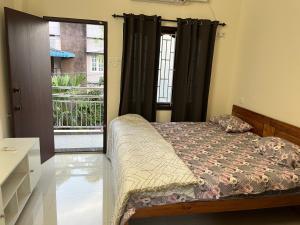 a bedroom with a bed and a door to a balcony at Zion Inn Home Stay in Eraniel