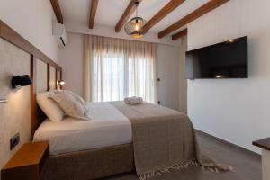 a bedroom with a bed and a large window at Prasonisi Villas in Kattavía