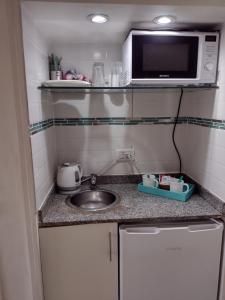 a small kitchen with a sink and a microwave at Departamento Corrientes Av. in Buenos Aires