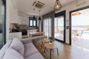 a living room and kitchen with a couch and tables at Prasonisi Villas in Kattavía