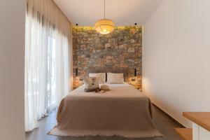 a bedroom with a large bed and a brick wall at Prasonisi Villas in Kattavía