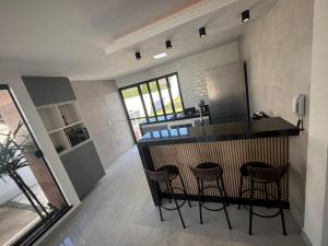 a kitchen with a counter and stools in a room at Beach Loft - Design e Estilo in Maricá